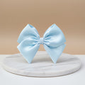 Light blue bow on a beige background
