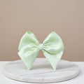 Light green bow on a marble stand with a beige background