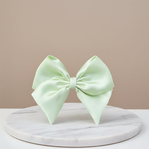 Light green bow on a marble stand with a beige background
